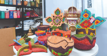 Foto de uma mesa com objetos criados a partir de reclicagem.